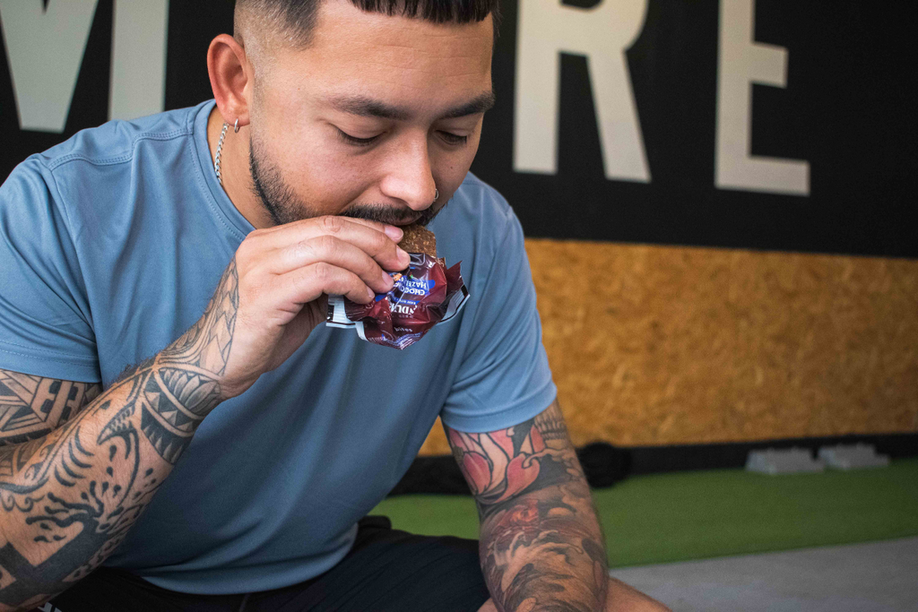 Sporter eating a functional bar in gym